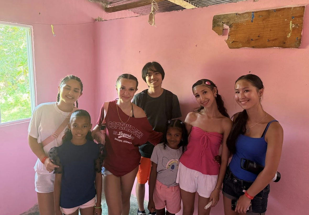 Volunteers and children together inside a freshly painted home